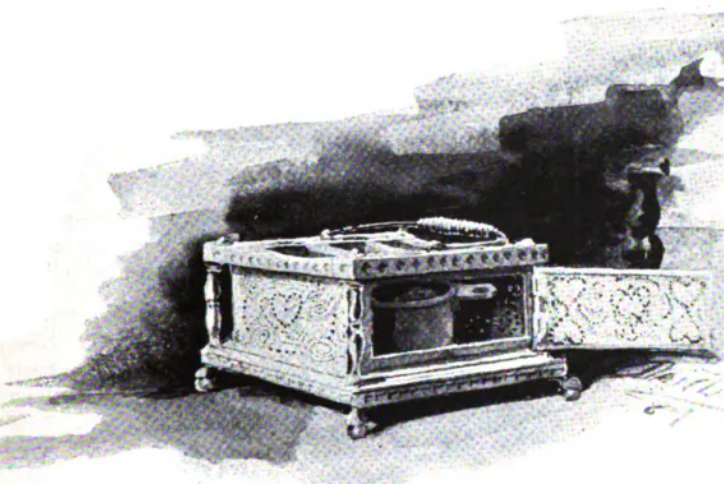 An antique foot-stove with a carved wooden frame and perforated metal sides, displayed with its door open to show the internal ash cup.