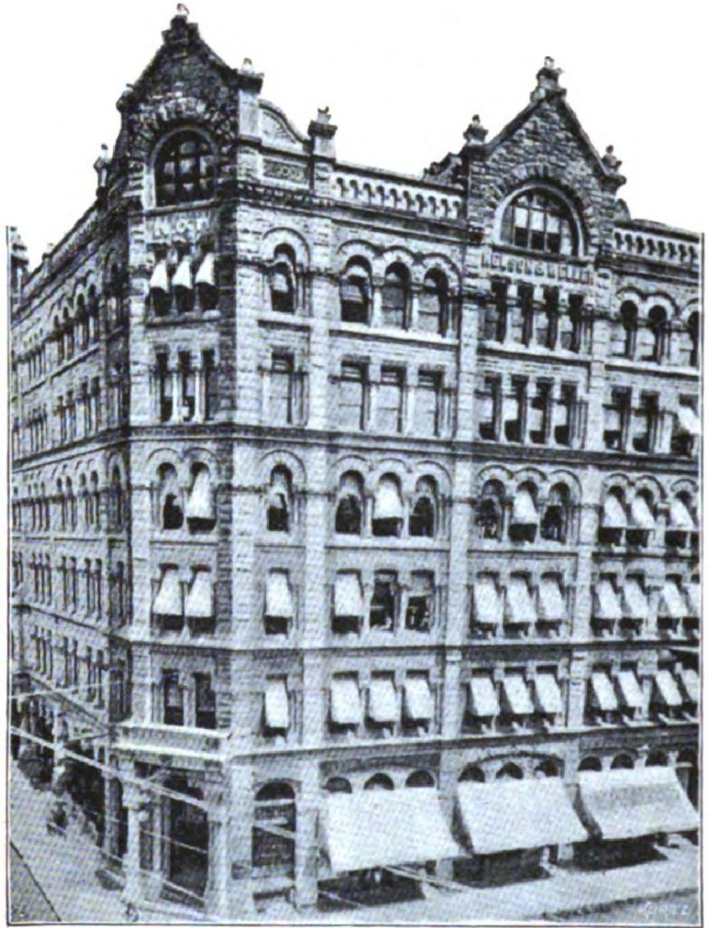 Stone commercial building with arched windows and ornate facade