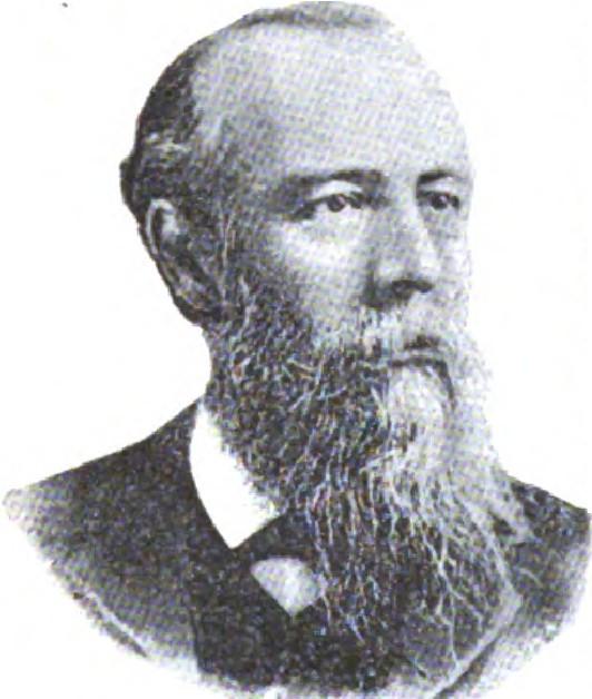 Man with gray hair and full beard in formal attire