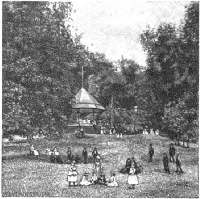 Park pavilion surrounded by trees with visitors on grounds