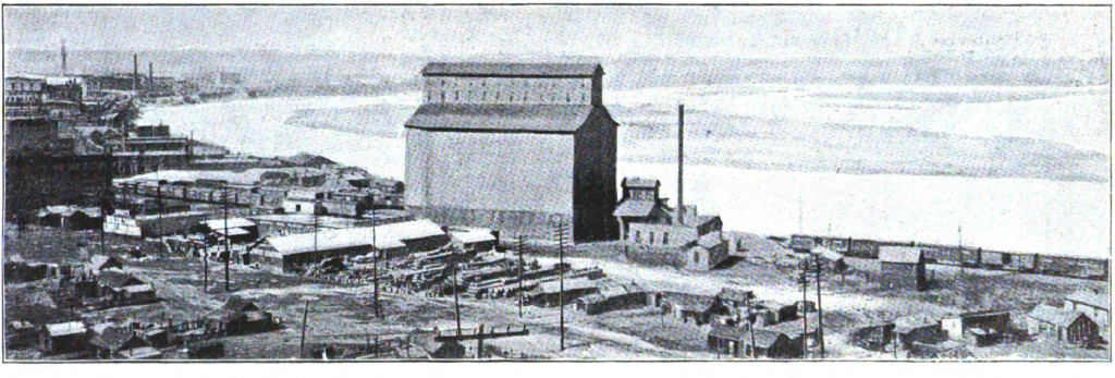 Railway bridge crossing Missouri River with industrial buildings